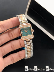 Gold and silver watch held by a hand with a black background